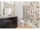 A convenient half bathroom, including decorative shower curtain and a dark wood vanity at 178 Windflower Way, Oviedo, FL 32765