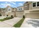 Exterior shot of townhomes with attached garages and landscaped front yards at 178 Windflower Way, Oviedo, FL 32765