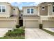 A view of the townhome's exterior, showcasing a well-maintained front yard and attached garages at 178 Windflower Way, Oviedo, FL 32765