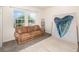 A comfortable living room boasts a cozy couch, two large windows, and a striking piece of artwork at 178 Windflower Way, Oviedo, FL 32765