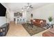 Open-concept living area with breakfast bar, neutral paint, tile flooring, ceiling fan, and television at 178 Windflower Way, Oviedo, FL 32765