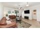 This living room features tile flooring, neutral paint, ceiling fan, a flat-screen television, and access to the patio at 178 Windflower Way, Oviedo, FL 32765