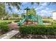 Community playground with a climbing wall and slide, surrounded by lush greenery and well-kept landscaping at 178 Windflower Way, Oviedo, FL 32765
