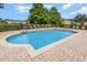 Community pool with lounge chairs surrounded by brick pavers in a well-maintained outdoor space at 178 Windflower Way, Oviedo, FL 32765