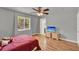 This bright bedroom features hardwood floors, a ceiling fan, and a window with a view at 1940 S Conway Rd # 8, Orlando, FL 32812
