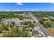 Overhead shot of property's proximity to nearby highway with abundant trees and green foliage under sunny, partly cloudy sky at 209 N 14Th St, Leesburg, FL 34748