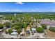 An aerial view of the property showcasing the home's location within a lush, green neighborhood on a sunny day at 209 N 14Th St, Leesburg, FL 34748