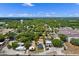 An aerial view of the property showcasing the home's location within a lush, green neighborhood on a sunny day at 209 N 14Th St, Leesburg, FL 34748
