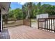 Backyard deck with wooden railing surrounded by lush foliage at 209 N 14Th St, Leesburg, FL 34748