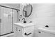 Updated bathroom features a modern vanity, round mirror, shiplap, and glass shower enclosure at 209 N 14Th St, Leesburg, FL 34748