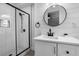 Bathroom featuring modern vanity, round mirror, shiplap accent wall and glass shower at 209 N 14Th St, Leesburg, FL 34748