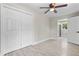 Bedroom featuring wood-look tile floors, closet, ceiling fan, and adjacent rooms at 209 N 14Th St, Leesburg, FL 34748