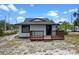 Beautiful home with a black roof and trim, complemented by a welcoming wooden deck entrance at 209 N 14Th St, Leesburg, FL 34748