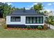 Charming home showcasing a black and white exterior paint scheme, manicured lawn, and contrasting mulch at 209 N 14Th St, Leesburg, FL 34748