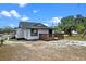Charming single story home with a black roof and a lovely wooden deck on a sunny day at 209 N 14Th St, Leesburg, FL 34748