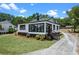 Newly renovated bungalow showcasing manicured lawn, black and white exterior, and stained staircase at 209 N 14Th St, Leesburg, FL 34748