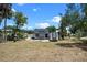 Expansive yard showcasing a charming home with a cozy wooden deck for outdoor enjoyment at 209 N 14Th St, Leesburg, FL 34748