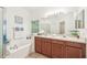 Bathroom featuring a soaking tub with tile surround and double sink vanity with ample counter space at 2246 Florida Soapberry Blvd, Orlando, FL 32828