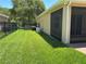 Backyard with a view of the screen enclosed porch and black aluminum fence at 2258 Rickover Pl, Winter Garden, FL 34787