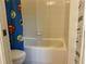 A bathroom featuring a bathtub with white tile and a fun superhero shower curtain at 2258 Rickover Pl, Winter Garden, FL 34787