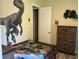 Fun bedroom with dinosaur-themed decor, a mounted dinosaur head, and a Jurassic Park bedspread at 2258 Rickover Pl, Winter Garden, FL 34787
