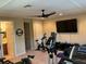 This home gym features modern exercise equipment, ceiling fan, and a large TV at 2258 Rickover Pl, Winter Garden, FL 34787