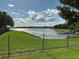 Scenic lake view with grassy lawn and a bright blue sky filled with puffy clouds, providing a serene and picturesque backdrop at 2258 Rickover Pl, Winter Garden, FL 34787