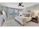 Bright bedroom features plush carpet, fan and decorative light fixture, and large windows with peaceful outdoor views at 2335 Green Symphony Pl, Oviedo, FL 32765