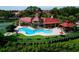 Community pool with turf lawn, jacuzzi, red roof cabana and tower feature, surrounded by black metal fence and lush trees at 234 Afton Sq # 305, Altamonte Springs, FL 32714