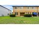 Expansive backyard featuring lush green grass, trimmed shrubs, and a glimpse of the home's neutral exterior at 2502 Seven Oaks Dr, St Cloud, FL 34772