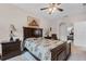 Bright bedroom features ceiling fan, wood bed frame, and an ensuite bathroom at 2502 Seven Oaks Dr, St Cloud, FL 34772