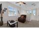 Upstairs bonus room with a comfy chair, large window, ceiling fan, and neutral carpeting at 2502 Seven Oaks Dr, St Cloud, FL 34772