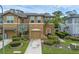 Inviting exterior showcasing a well-maintained townhome with a two-car garage and lush greenery at 2502 Seven Oaks Dr, St Cloud, FL 34772