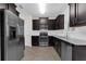 Modern kitchen featuring stainless steel appliances, dark cabinetry, and granite countertops at 2502 Seven Oaks Dr, St Cloud, FL 34772