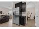 Kitchen features a stainless steel refrigerator, dark wood cabinets, and leads into the dining area and living room at 2502 Seven Oaks Dr, St Cloud, FL 34772