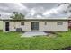 View of the backyard with a grassy area, small patio, and the rear exterior of the house at 26 Channing Ave, Orlando, FL 32811