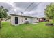Backyard view showcasing a grassy lawn, patio area, and the house's exterior at 26 Channing Ave, Orlando, FL 32811