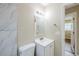 Bathroom with white marble-look tile, sink and vanity with modern lighting fixtures at 26 Channing Ave, Orlando, FL 32811