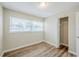Bright bedroom featuring wood-look flooring, neutral walls, and a closet with natural light at 26 Channing Ave, Orlando, FL 32811