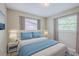 Bedroom featuring neutral walls, bedside tables, and a bed with a blue comforter at 26 Channing Ave, Orlando, FL 32811