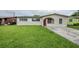 Charming single-story home featuring a red front door, well-maintained lawn, and inviting curb appeal at 26 Channing Ave, Orlando, FL 32811