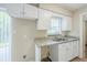 Bright kitchen sink area with granite countertops, white cabinets, and a window view at 26 Channing Ave, Orlando, FL 32811