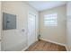 Utility room with wood-look flooring, window, and door to the exterior at 26 Channing Ave, Orlando, FL 32811
