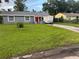 This lovely single-story home has a gray exterior, a spacious lawn, and a cheerful red front door at 2847 W Harwood St # 0, Orlando, FL 32805