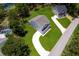 Beautiful aerial shot of a home with a pool, lush greenery, and a charming driveway, all near a tranquil lake at 300 Mitnik Dr, Deltona, FL 32738