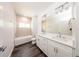 Bright bathroom featuring double vanity, white cabinets, and tiled shower at 300 Mitnik Dr, Deltona, FL 32738