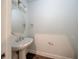 Clean half bath features a modern pedestal sink, round mirror, and neutral paint scheme at 300 Mitnik Dr, Deltona, FL 32738