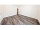 An empty bedroom with wood-look floors, base trim, bright white walls and a white door at 300 Mitnik Dr, Deltona, FL 32738