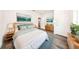 A staged bedroom with a comfortable bed, nightstands, dresser, art, and wood-look floors at 300 Mitnik Dr, Deltona, FL 32738