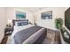 This staged bedroom is decorated with modern furniture, artwork, and wood-look floors at 300 Mitnik Dr, Deltona, FL 32738